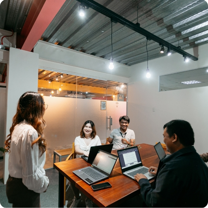 4(2) A girl explaining to her workmates what EOR is about and how helpful this is to global business wanting to scale at a lesser price