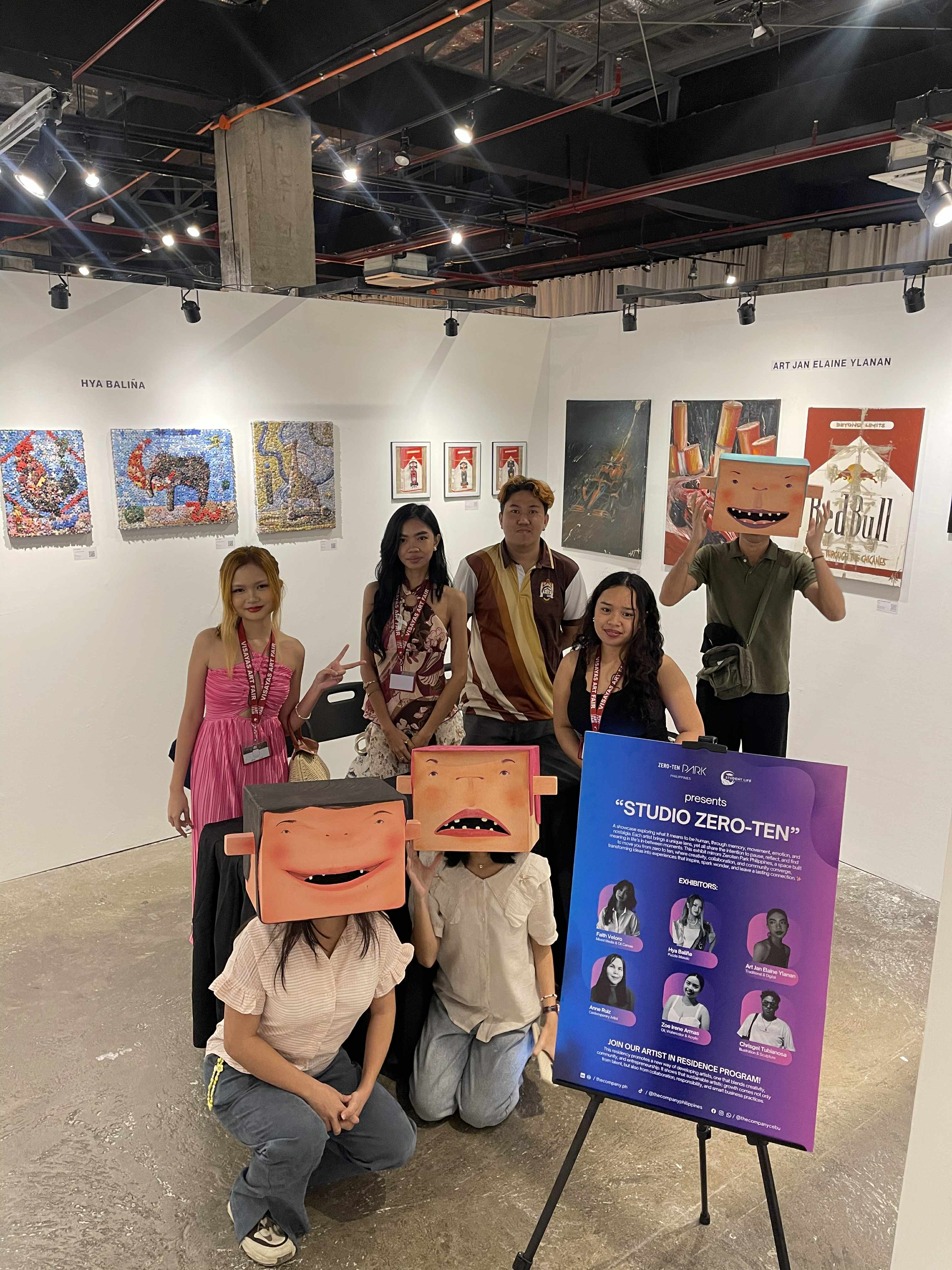 Zero-Ten Park at Visayas Art Fair 2025 artists and student volunteers posing inside the booth with the Studio Zero-Ten exhibit sign.